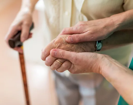 Caregiver guiding patient with a cane